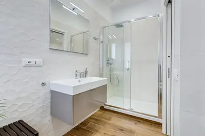 a white bathroom with a sink and a shower at San Pietro Vatican Apartments in Rome