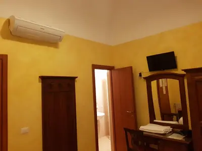 a bathroom with a mirror and a air conditioner on the wall at Guest House Pitagora in Rome