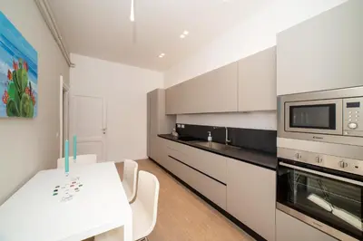 a white kitchen with a table and a microwave at Appia96 Apartments in Rome