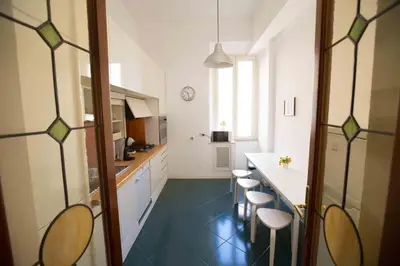 a bedroom with a white bed and a wooden floor at A 10 passi dal Vaticano in Rome