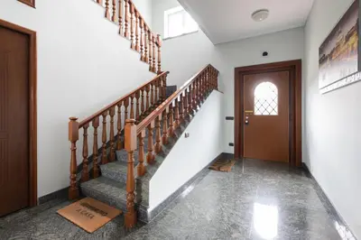 a hallway with stairs and a wooden door at Castelbarco House F in Rome