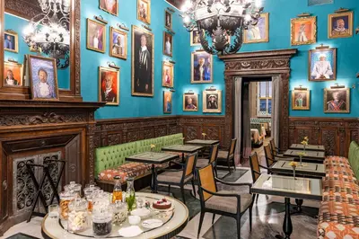 a restaurant with blue walls and tables and chairs at Palazzo Roma - The Leading Hotels of the World in Rome