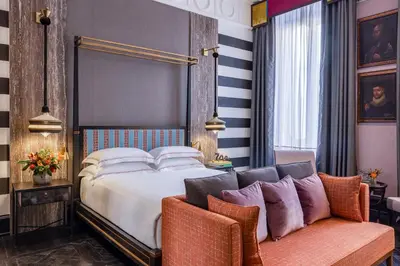 a bedroom with a bed and two chairs at Palazzo Roma - The Leading Hotels of the World in Rome