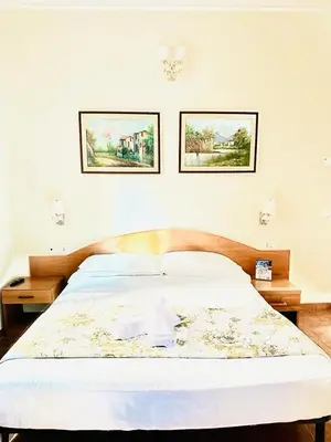 a bed in a bedroom with two pictures on the wall at Hotel Resi in Rome