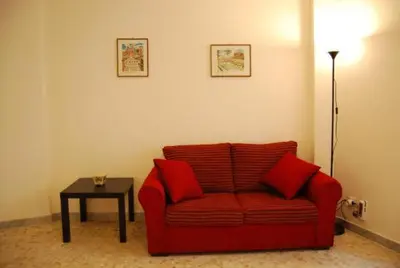 a living room with a red couch and a table at Residenza Flaminia in Rome