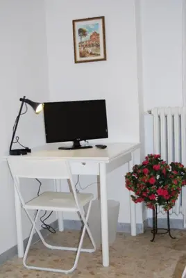 a white desk with a computer monitor and a plant at Residenza Flaminia in Rome
