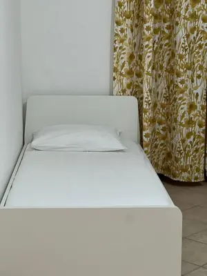 a white bed in a room with a curtain at Signorina In Rome in Rome