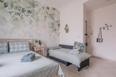 a bedroom with two beds and a wall with flowers at San Giovanni Dream House in Rome