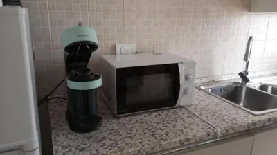 a microwave sitting on a counter next to a sink at DOMUS VACANZE ROMANE in Rome