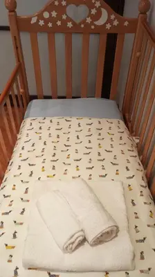 a crib with a blanket on it with a bear pattern at DOMUS VACANZE ROMANE in Rome