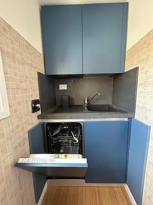 a kitchen with a sink and blue cabinets at Manzoni Blue House by GHOR in Rome