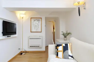 a living room with a white couch and a tv at Fontanella Borghese CORI apartment in Rome