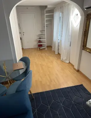 a living room with a blue couch and wooden floors at PARIOLI LUXURY SUITe II in Rome