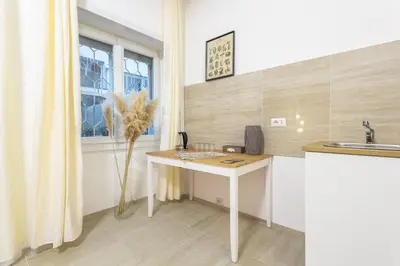 a kitchen with a white desk and a window at Ethnos Relais Vaticano in Rome