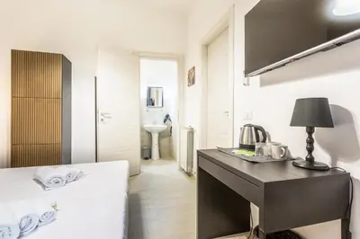 a bedroom with a bed and a desk with a lamp at Ethnos Relais Vaticano in Rome