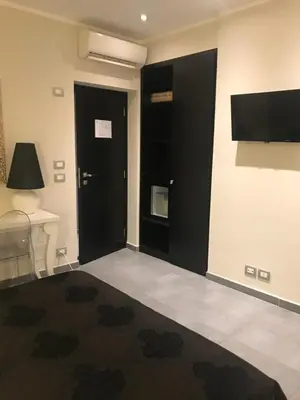 a room with a black door and a television at Gemini Suite in Rome