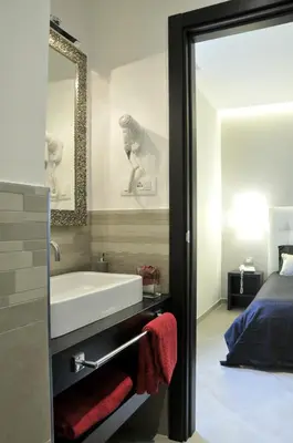 a bathroom with a tub and a sink and a bed at Gemini Suite in Rome