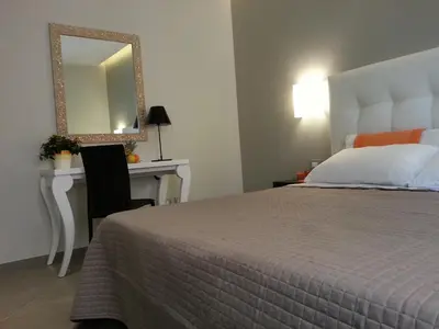 a bedroom with a bed and a dresser with a mirror at Gemini Suite in Rome
