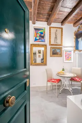 a dining room with a table and a green door at Intimo ed Eclettico Studio a Trastevere in Rome