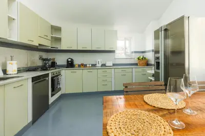 a kitchen with white cabinets and a wooden table at Nikis Maison Navona - 4th floor no elevator in Rome