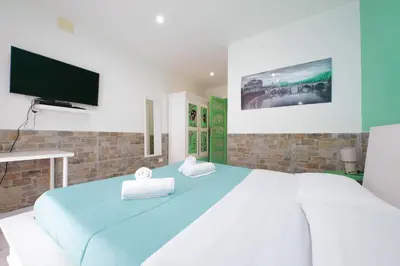 a bedroom with a large bed and a flat screen tv at Lucky Domus Appio in Rome