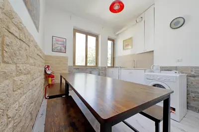 a kitchen with a wooden table in a room at Lucky Domus Appio in Rome