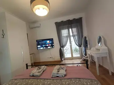 a bedroom with a bed and a tv and a window at CasaLara Garden in Rome