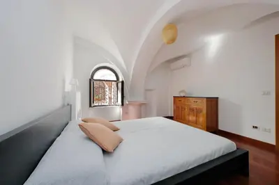 a bedroom with a large bed and a window at Colosseo Family Apartment Capo d'Africa AC/wifi in Rome