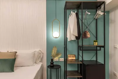 a bedroom with a bed and a blue wall at 94Rooms Vatican Guest House - Vigliena in Rome