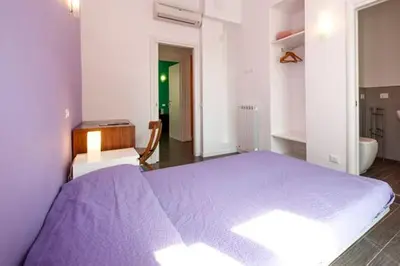 a bedroom with a large purple bed and a bathroom at Bed & Puppets in Rome