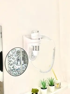 a bathroom with a mirror and a hair dryer at “Suite Home Vaticano City” in Rome