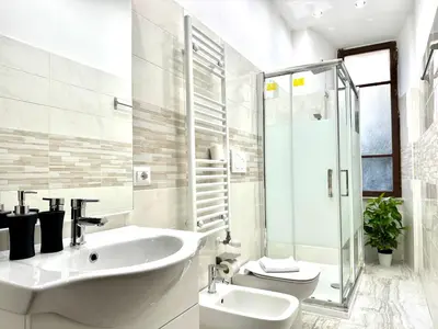 a white bathroom with a sink and a shower at Vatican home in Rome