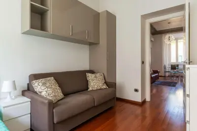 a living room with a couch and a dining room at GuestHost - Vittorio Emanuele Elegant Apartment in Rome