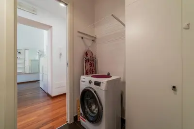 a washer and dryer in a room with a hallway at GuestHost - Vittorio Emanuele Elegant Apartment in Rome