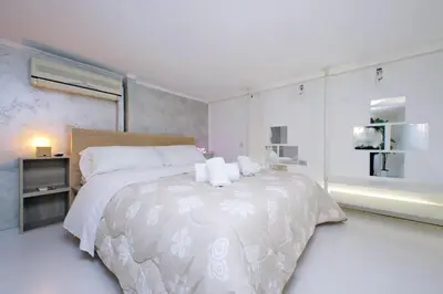 a white bedroom with a large bed with white sheets at Vatican d'Elite in Rome