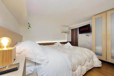 a bedroom with a large white bed with a clock on the wall at Vatican d'Elite in Rome