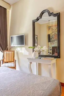 a bedroom with a table with a mirror and a tv at Cristina's Home in Rome