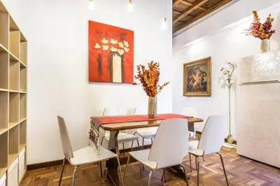 a dining room with a table and white chairs at sacra mysteria vatican in Rome