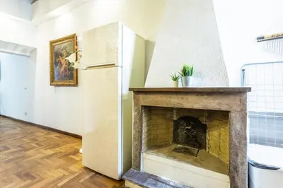 a living room with a fireplace and a refrigerator at sacra mysteria vatican in Rome