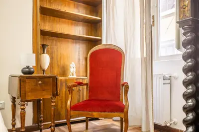 a red chair sitting in a room with a window at sacra mysteria vatican in Rome