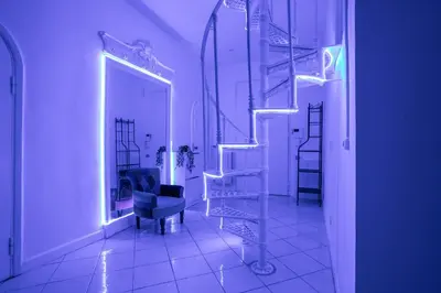a staircase in a room with a chair and a mirror at sacra mysteria vatican in Rome
