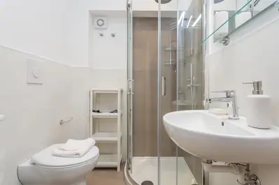 a bathroom with a sink and a toilet and a shower at Prati 3BDR Urban Charm in Rome