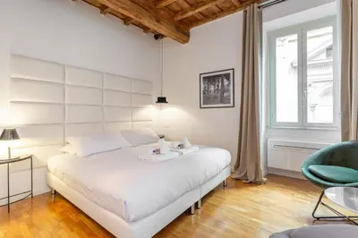 a bedroom with a white bed and a blue chair at Eclectica Living by Navona Square in Rome