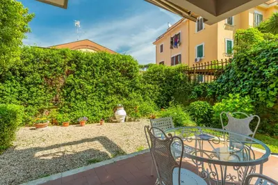 a patio with a table and chairs in a yard at St Peters Garden 3 BDR Apartment in Rome