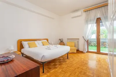 a white bedroom with a bed and a table at St Peters Garden 3 BDR Apartment in Rome