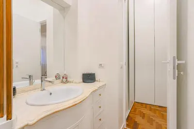 a white bathroom with a sink and a mirror at Piazza Navona Deluxe Apartment - Piano 2 Roma in Rome