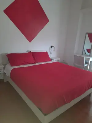 a red bed with red pillows in a bedroom at Casa Miso in Rome