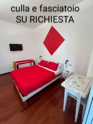 a bedroom with a red bed and a table at Casa Miso in Rome