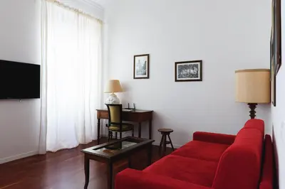 a living room with a red couch and a table at EasySleep Vaticano in Rome