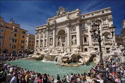 a crowd of people standing around a fountain in front of a building at Suite Design Piazza di Spagna in Rome